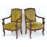 A pair of early / mid 19thC mahogany Empire armchairs, having shaped top rails above scrolled arms