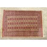 Carpet / Rug : A rug with a red and cream ground decorated with banded geometric detail. Approx.
