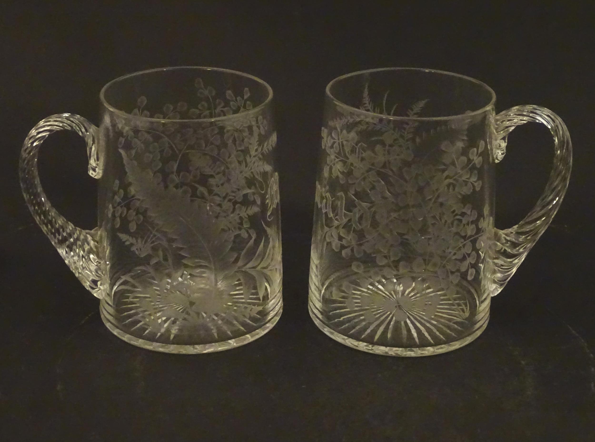 Two 19thC glass tankards with twist handles and engraved foliate decoration. One titled 'Mary',