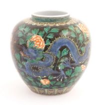 A Chinese famille noir vase decorated with two dragons and a flaming pearl amongst flowers and