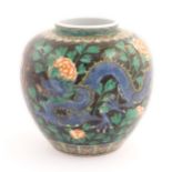 A Chinese famille noir vase decorated with two dragons and a flaming pearl amongst flowers and