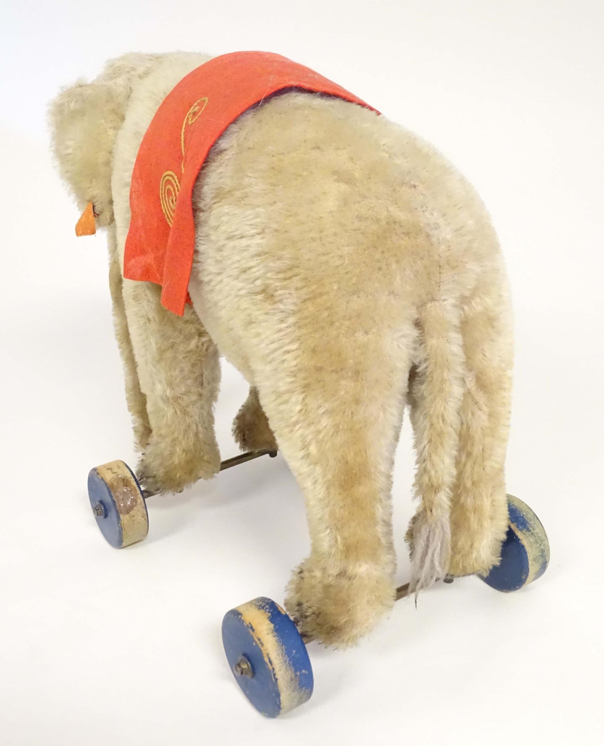 Toy: An early 20thC Steiff mohair pull along elephant toy with felt saddle, upon four wooden wheels, - Image 4 of 9