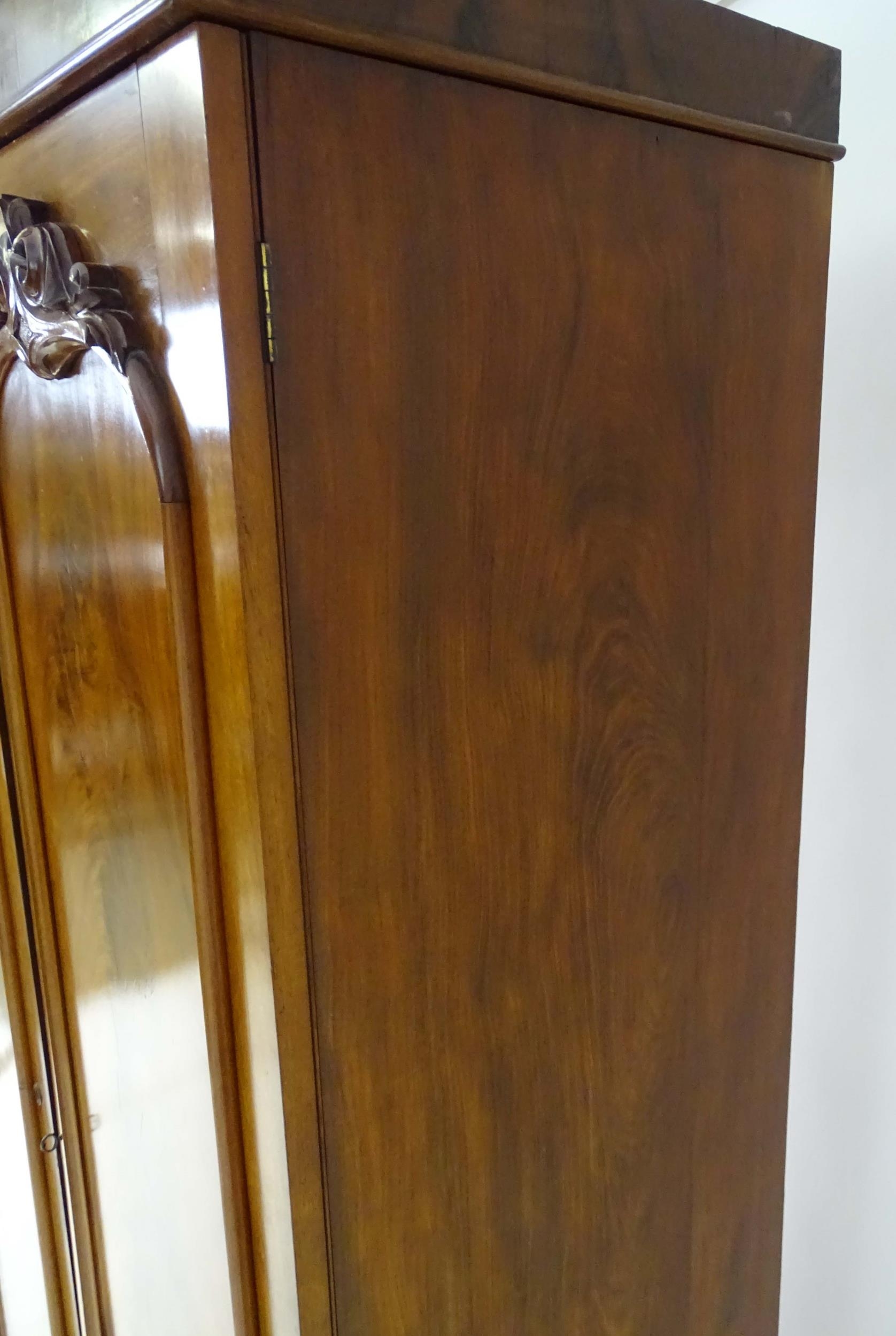 A mid 19thC mahogany double wardrobe with two panelled doors adorned with carved foliage and opening - Image 8 of 9