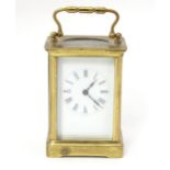 A carriage clock with brass case and enamel dial. Approx. 5 1/2" high overall. Please Note - we do