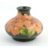 A Moorcroft squat vase decorated in the Hibiscus pattern. Marked under. Approx. 4" high Please