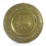 A large 20thC Indian brass charger with embossed decoration depicting an Indian procession with