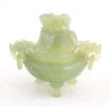A Chinese carved light jade coloured hardstone censer and cover raised on three feet, with twin