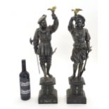 A pair early 20thC Continental cast metal figures depicting musketeers / knights holding aloft a