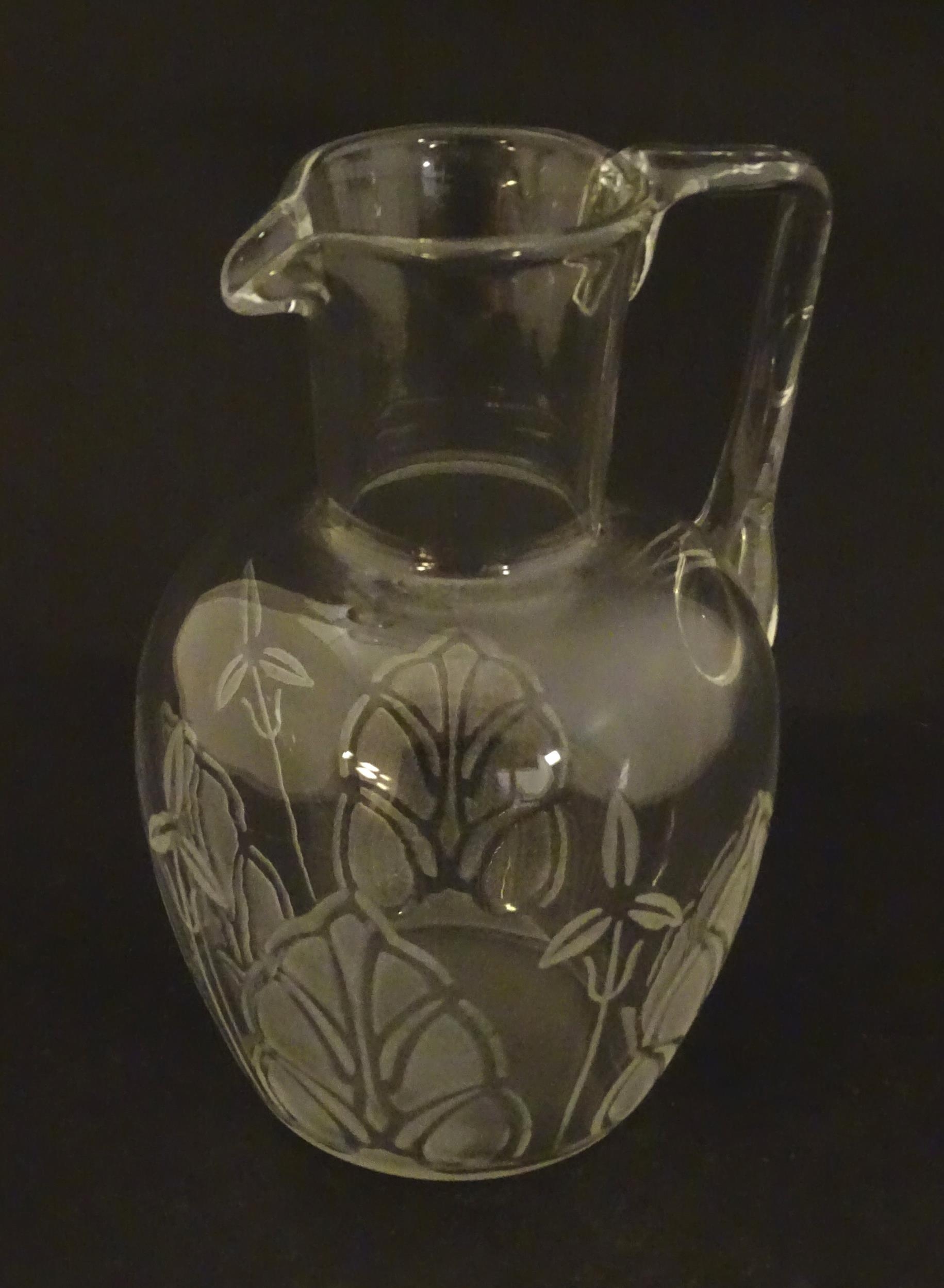 A glass water jug with foliate detail Approx 7" high Please Note - we do not make reference to the - Image 3 of 6