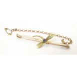 A 9ct gold bar brooch set with dragonfly to centre having sapphire detail. 2" wide Please Note -