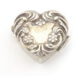 A silver pill box of heart form with embossed decoration and hinged lid. Hallmarked London 1988