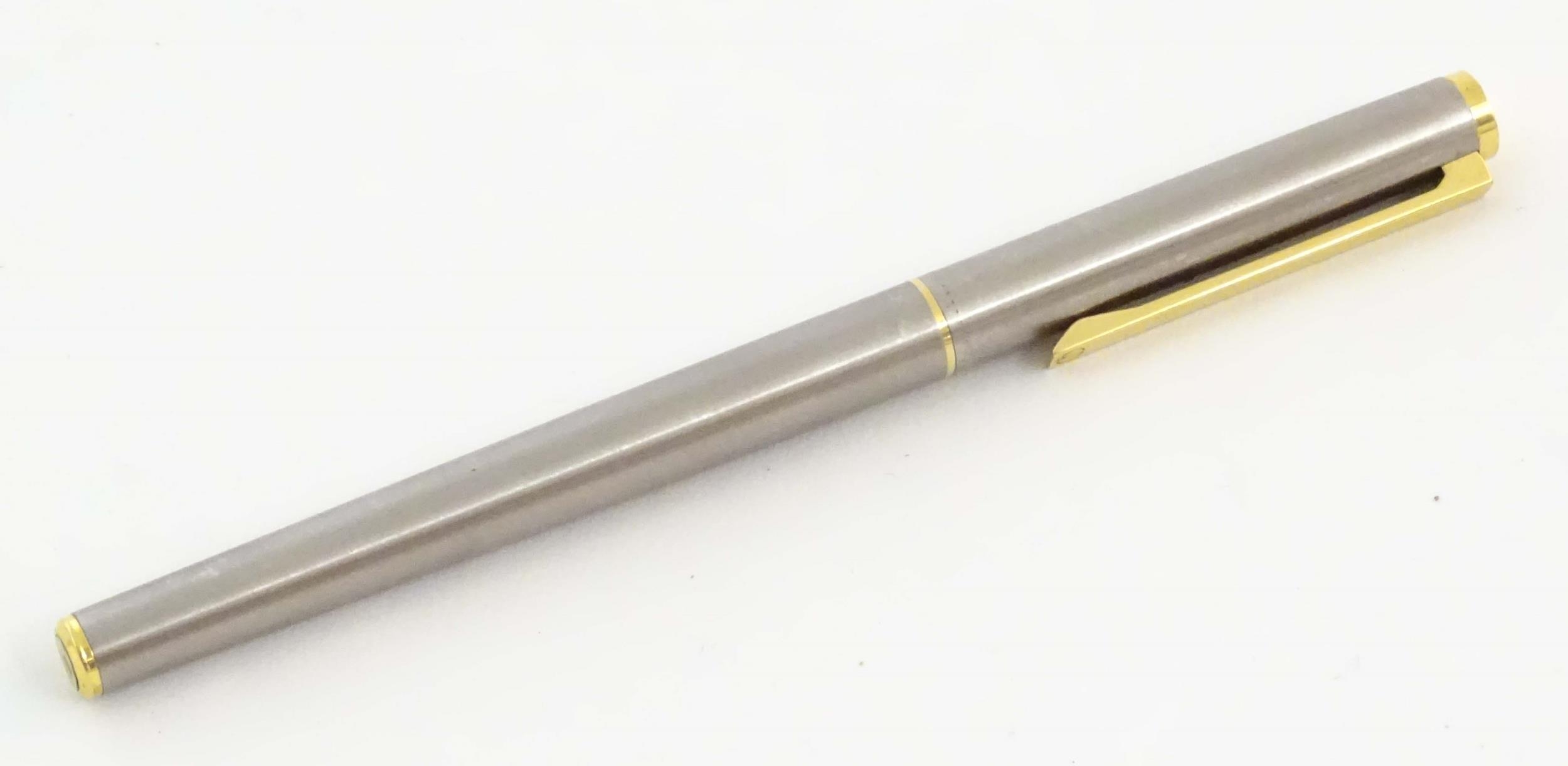 A Dunhill fountain pen, with rolled finish, gilt mounts and 14K gold nib. Approx. 5 1/2" long Please