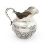 A small Continental .800 silver cream jug with ribbon and swag decoration. Marked under possibly