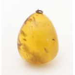 A vintage amber pendant. Approx. 2" long Please Note - we do not make reference to the condition