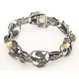 A hunting trophy bracelet set with deer teeth within a white metal .800 silver mounts with oak