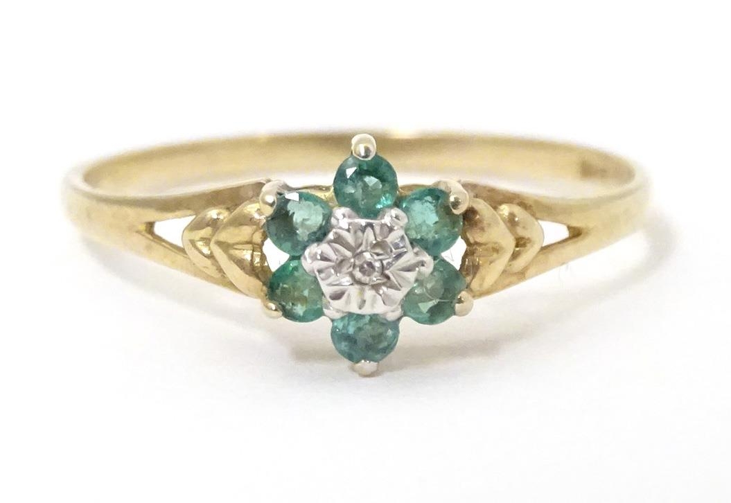 A 9ct gold ring set with central diamond bordered by emeralds. Ring size approx. S 1/2 Please Note -