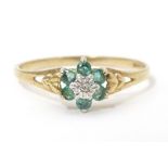 A 9ct gold ring set with central diamond bordered by emeralds. Ring size approx. S 1/2 Please Note -