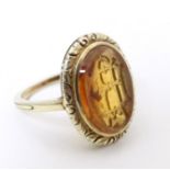 A late 19th / early 20thC yellow metal ring with engraved citrine seal to top depicting monogram.