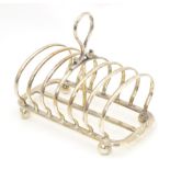 A silver plate seven bar toast rack. Approx. 5 1/4" long Please Note - we do not make reference to