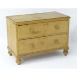 A 19thC pine chest of drawers with a moulded rectangular top above two long drawers with turned