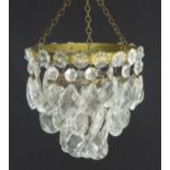 An early 20thC crystal drop bag pendant chandelier, the circular gilt metal mounts supporting