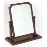 A Regency period mahogany dressing / toilet mirror with a shaped crossbanded surround supported by