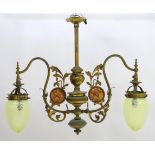 An Art Nouveau brass twin branch pendant ceiling light, decorated with copper roundels depicting a