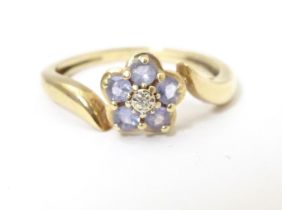 A 9ct gold ring set with central diamond bordered by five tanzanite stones. Ring size approx. N 1/