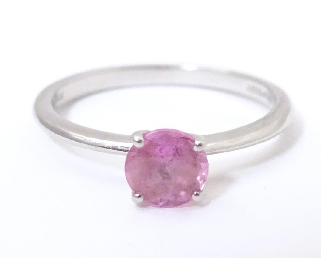 A platinum ring set with pink sapphire solitaire. Ring size approx. O Please Note - we do not make