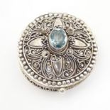 A .925 silver pill box with hinge lid and blue paste stone to top. Approx. 1 1/4" diameter Please
