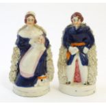 A pair of Victorian Staffordshire pottery figures depicting Queen Victoria seated holding a child,