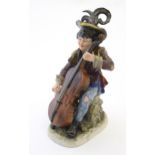 A Continental figure modelled as a female musician playing the cello wearing a hat with a feather.