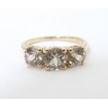 A 9ct gold ring set with a trio of yellow (csarite) stones. Ring size approx. L Please Note - we