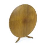 A Regency mahogany breakfast table with a circular top decorated with ebonised stringing and