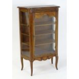 A Louis XV style vitrine / glazed cabinet with a shaped top above a glazed door and sides, the