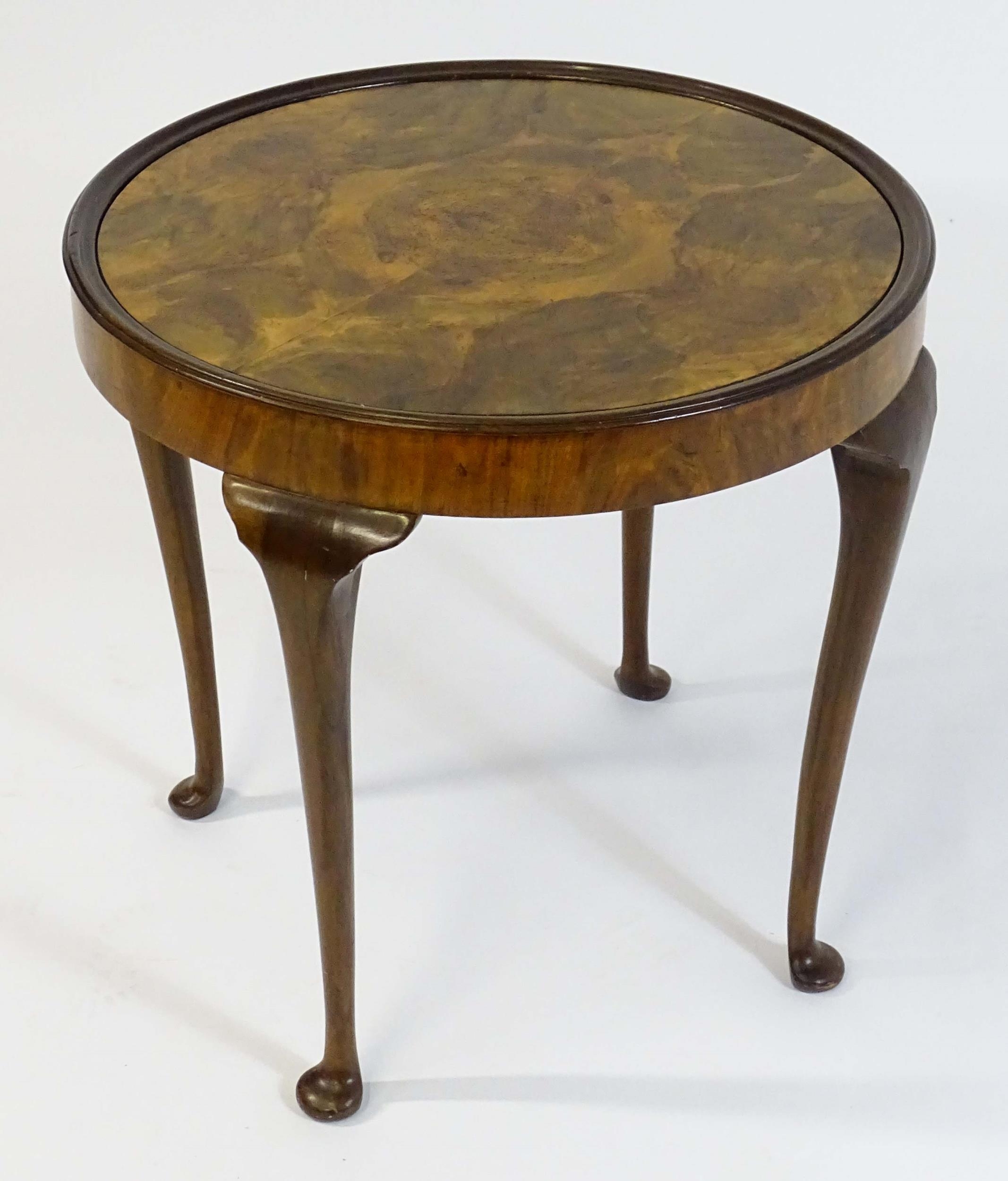 An early / mid 20thC walnut occasional / games table with a reversible top above four cabriole