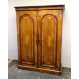 A mid / late 19thC walnut wardrobe with a carved cornice above two burr walnut veneered doors with