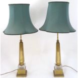 A pair of mid 20thC brass table lamps, the squared stepped bases supporting cut glass sections and