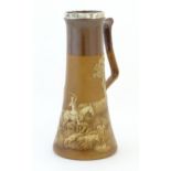 A Royal Doulton two tone jug of elongated form, with relief decoration depicting hunting scenes with