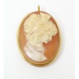A carved cameo brooch within a gold mount. Approx 1 1/2" long Please Note - we do not make reference