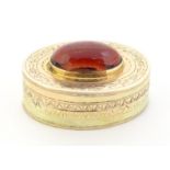 A Victorian yellow metal vinaigrette with engraved decoration set with garnet cabochon to top,