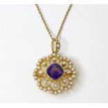 A late 19th / early 20thC gold pendant / brooch set with seed pearls and central amethyst, with a