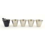 A cased travelling set of four stainless steel tot cups within a leather case, each 2 1/2" tall