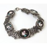 A silver bracelet set with 5 oval panel with pietra dura style decoration. Approx 7 3/4" long Please