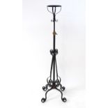 An Arts & Crafts wrought iron and copper telescopic lamp stand, standing on four scrolling legs