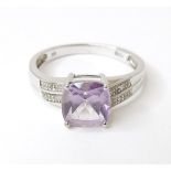 A 9ct white gold ring set with central amethyst flanked by diamonds. Ring size approx. P Please Note