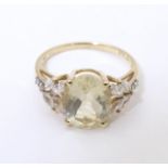 A 9ct gold dress ring set with central oval serenite flanked by four white topaz to each shoulder.