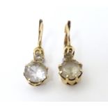 A pair of yellow metal drop earrings set with claw set white stones 1" long Please Note - we do