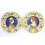 Two Italian majolica portrait plates with folate and mask detail to borders. Signed under S Volpi,