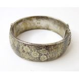 A silver bracelet of bangle form with engraved floral and foliate decoration. Hallmarked Chester